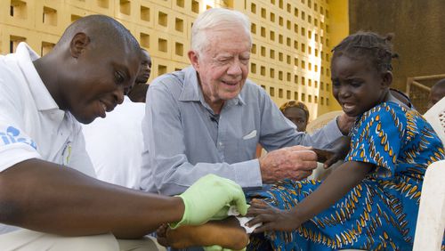 Jimmy Carter consoles a young patient having a worm removed from her body in Savelugu, Ghana, in February 2007. The Carter Center leads the international campaign to eradicate Guinea worm disease. (The Carter Center)