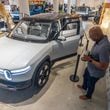 Rivian employee Russ Mooney looks over the new R2 prototype, which the company says will eventually be made in Georgia, at the Ponce City Market in Atlanta on April 27, 2024. (Steve Schaefer / AJC)