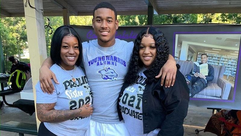 Artez Benton, center, poses with his sisters Arteria, left, and Bria after he graduated from Young Harris College last year.