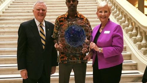 Mausiki Scales receives his award from Gov. Nathan Deal and First Lady Sandra Deal.