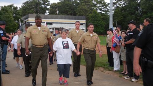 USMC Lance Cpl. Skip Wells' mother Cathy Wells is escorted into the stadium. Photo: Jennifer Brett