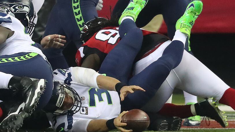 The Falcons defense upends Seahawks quarterback Russell Wilson in the end zone for a safety to cut the Seahawks lead to 10-9 during the second quarter in a NFL football NFC divisional playoff game on Saturday, Jan. 14, 2017, in Atlanta. Curtis Compton/ccompton@ajc.com
