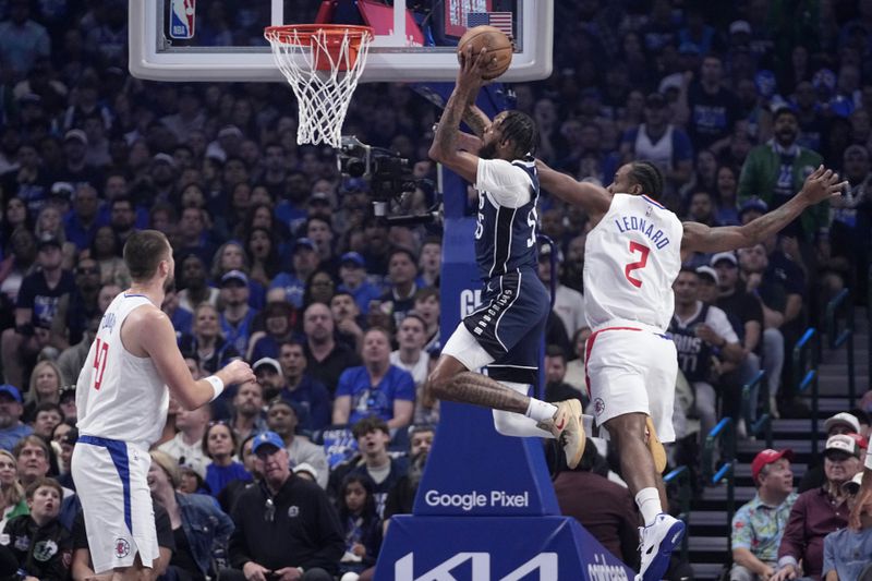 Dallas Mavericks forward Derrick Jones Jr. (55) goes for a dunk between Los Angeles Clippers' Ivica Zubac (40) and Kawhi Leonard (2) during the first half of Game 2 in an NBA basketball first-round playoff series Friday, April 26, 2024, in Dallas. (AP Photo/Tony Gutierrez)
