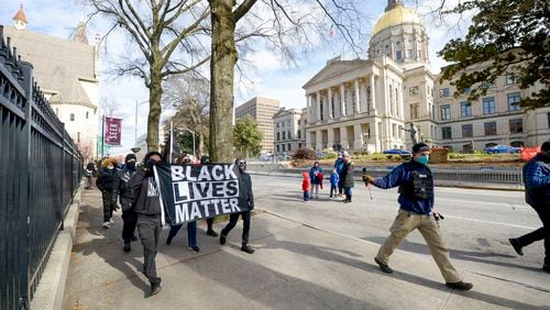 A group of six individuals representing Black Lives Matter marches along Washington Avenue in front of the state Capitol on Sunday, January 17, 2021, in Atlanta. (Photo: Daniel Varnado for The Atlanta Journal-Constitution)