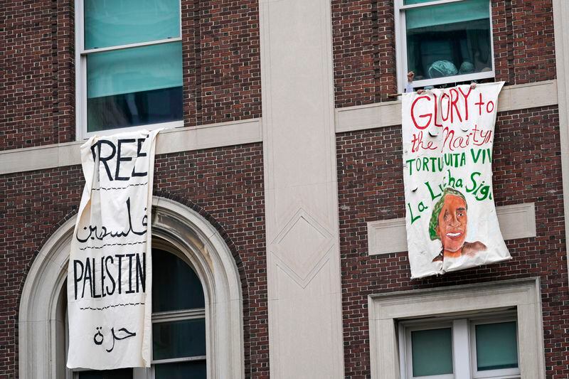 FILE - A demonstrator pumps his fist as he hangs a sign from a window in Hamilton Hall inside the Columbia University campus, Tuesday, April 30, 2024, in New York. (AP Photo/Mary Altaffer, File)