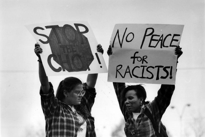 Two demonstrators in Atlanta hold signs that state “Stop the chop!” and “No peace for racists!” in 1993 as the Atlanta Braves prepared to face off against the Los Angeles Dodgers. Native Americans leaders staged protests in the 1990s against Braves fans who dressed as American Indians and did the tomahawk chop. (photo credit: Jonathan Newton)