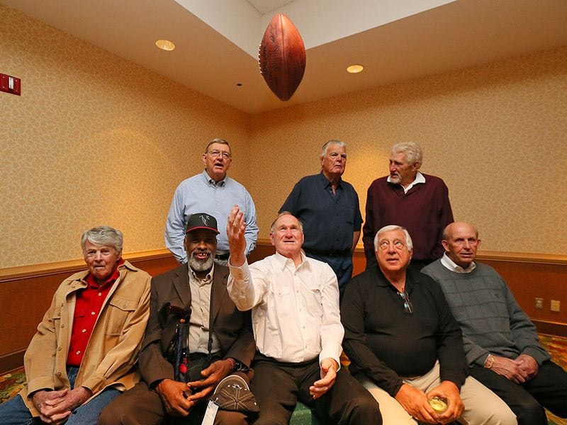 Ken Reaves (second from left, front) often joins former teammates for Falcons alumni festivities. Players from the 1966 Falcons team gather during a reunion around the Falcons first-ever draft pick Tommy Nobis tossing a football in the air in 2013, at Lake Lanier Islands Resort. Front (from left) are general manager Tom Braatz, Reaves, linebacker Tommy Nobis, linebacker Ralph Heck, and wide receiver Gary Barnes. Back row (from left) are kicker Lou Kirovac, tackle Don Talbert, and tight end Bill Martin. (Curtis Compton/AJC)