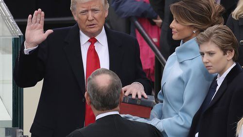WASHINGTON, DC - JANUARY 20:  Supreme Court Justice John Roberts (2L) administers the oath of office to U.S. President Donald Trump (L) as his wife Melania Trump holds the Bible and son Barron Trump looks on, on the West Front of the U.S. Capitol on January 20, 2017 in Washington, DC. In today's inauguration ceremony Donald J. Trump becomes the 45th president of the United States.  (Photo by Drew Angerer/Getty Images)