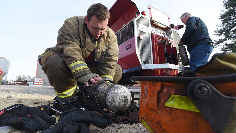 Firefighter recruit Caleb Tackett prepares his equipment at Catoosa County Fire Department station 10 in Rossville on Tuesday, November 22, 2022. (Photo Courtesy of Matt Hamilton)