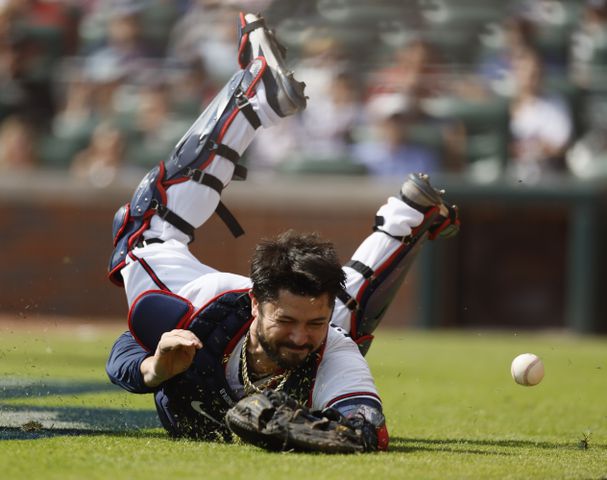 Atlanta Braves' Travis d'Arnaud dives for a foul ball during the fourth inning of game one of the baseball playoff series between the Braves and the Phillies at Truist Park in Atlanta on Tuesday, October 11, 2022. (Jason Getz / Jason.Getz@ajc.com)