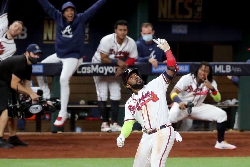 Braves designated hitter Marcell Ozuna celebrates his solo home run with a selfie pose with teammates in the background during Game 4 of the Championship Series against the Los Angeles Dodgers Thursday, Oct. 15, 2020, at Globe Life Field in Arlington, Texas. (Curtis Compton / Curtis.Compton@ajc.com)



