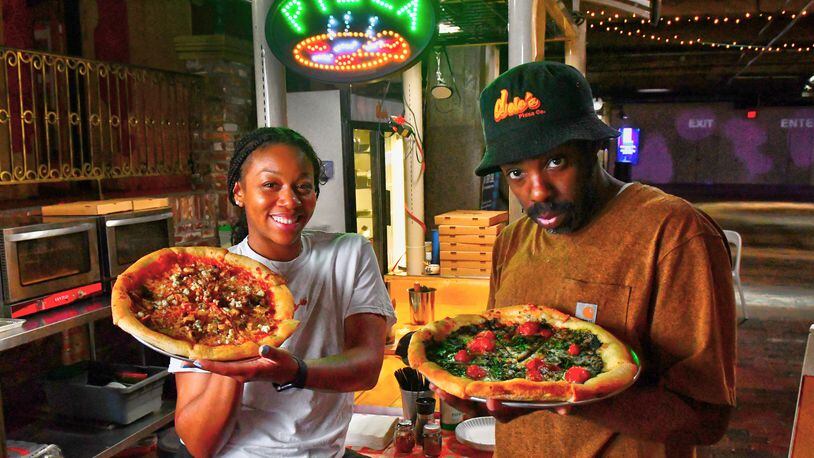 Dolo's Pizza owners Alyson Williams (left) and Yusef Walker show two of their creations at their pop-up pizzeria in Underground Atlanta. Chris Hunt for The Atlanta Journal-Constitution
