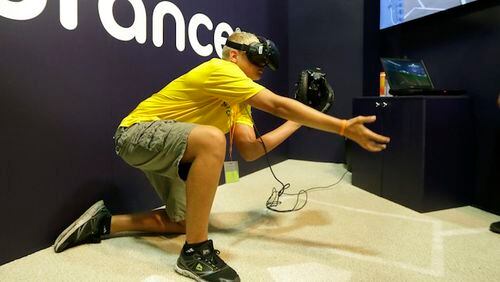 **HOLD FOR STORY BY RON BLUM FOR SUNDAY NIGHT JULY 9**Dennis Milman reaches to catch a virtual ball at the All Star FanFest, Friday, July 7, 2017, in Miami Beach, Fla. Fans put on goggles and a catcher mitt, crouch and get ready. They'll never catch a 104 mph from Aroldis Chapman. But at the All-Star FanFest they can feel like what it's like to be Buster Posey, receiving virtual pitches.(AP Photo/Alan Diaz)