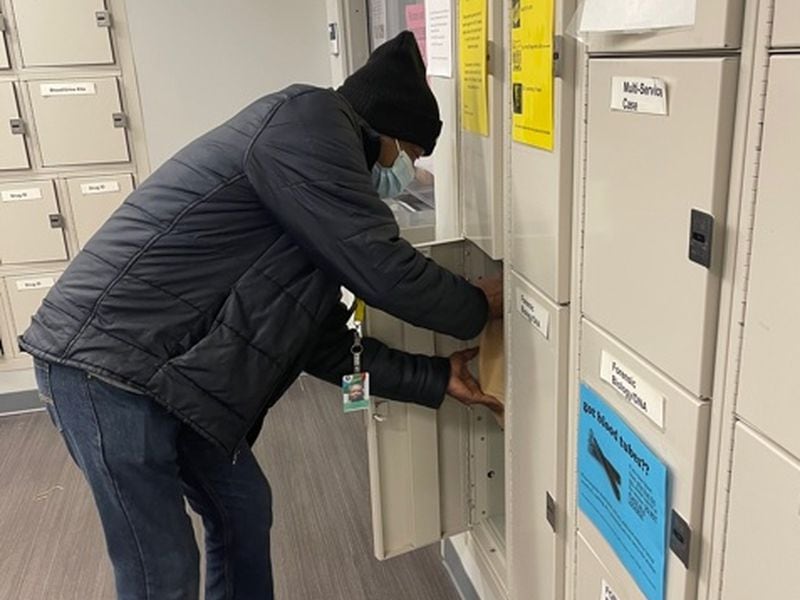 Eric Bailey places toxicology specimens inside a locker at the Georgia Bureau of Investigation's Crime Lab. Despite the toll his condition takes on him, he chooses to continue working full time as a Gwinnett County forensic investigator. (Courtesy of Shannon Volkodav)