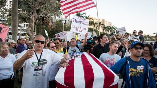Protesters push a casket representing the “Death of Democracy” down Flagler Drive in West Palm Beach as President Donald Trump and his wife Melania attend the 60th annual Red Cross Ball at the Mar-a-Lago on Saturday Feb. 4, 2017. (Michael Ares / The Palm Beach Post)