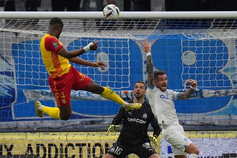 Lens' Kevin Danso heads the ball towards the goal during a French League One soccer match between Marseille and Lens at the Stade Velodrome stadium in Marseille, France, Sunday, April 28, 2024. (AP Photo/Daniel Cole)
