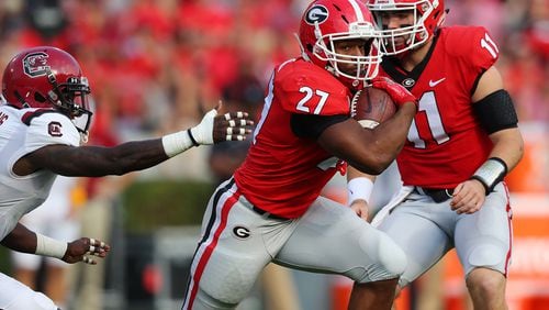 Georgia quarterback Jake Fromm hands off to  Nick Chubb for a long gain against South Carolina.