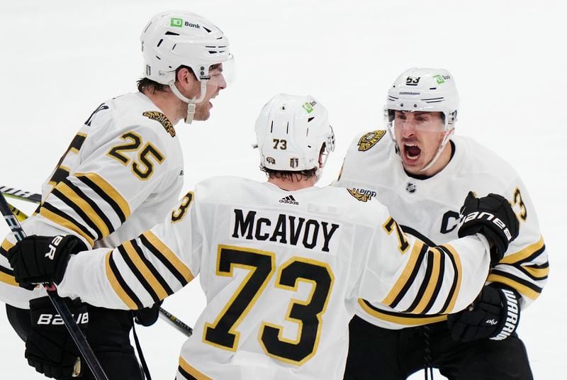 Boston Bruins' Brad Marchand (63) celebrates his goal against the Toronto Maple Leafs with Brandon Carlo (25) and Charlie McAvoy (73) during third period of action in Game 3 of an NHL hockey Stanley Cup first-round playoff series in Toronto on Wednesday, April 24, 2024. (Frank Gunn/The Canadian Press via AP)