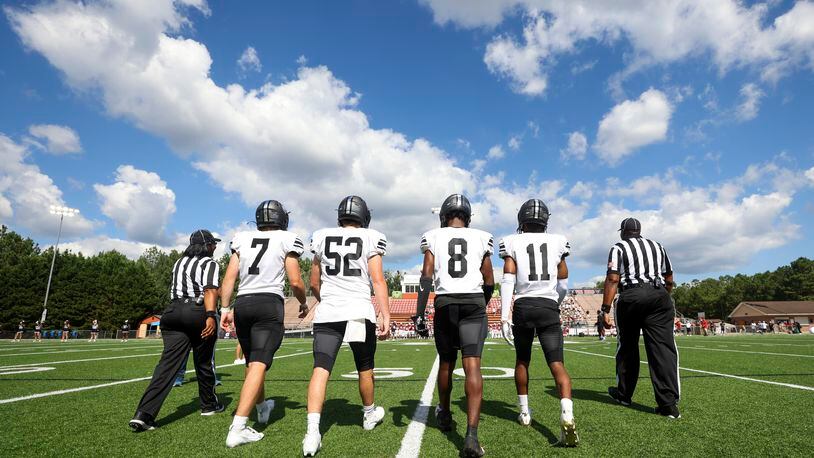 North Atlanta’s from left to right; Connor Hughes (7), Jackson Little (52), Dallas Ford (8), and Xaden Benson (11) walk to midfield for the coin toss before their game against Johns Creek in the 2023 Corky Kell + Dave Hunter Classic at Kell High School, Wednesday, August 15, 2023, in Marietta, Ga. (Jason Getz / Jason.Getz@ajc.com)