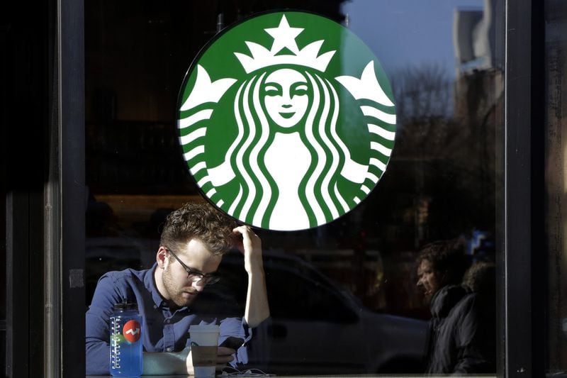 In this Jan. 11, 2016, photo, a man sits inside a Starbucks, in New York. The Seattle-based coffee chain is said to be considering Atlanta and other cities for a large amount of office space, potentially involving several hundred jobs. (AP Photo/Mark Lennihan)