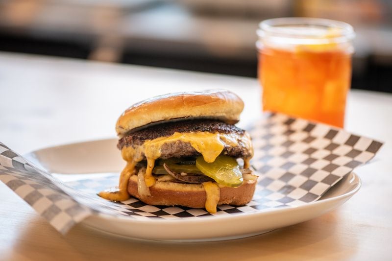 The Abby Singer Jucy Lucy is a half-pound of all-natural beef burger with molten American cheese, caramelized onions, and dill pickle chips. Its origin is a source of debate between the Twin Cities. (Mia Yakel for The Atlanta Journal-Constitution)