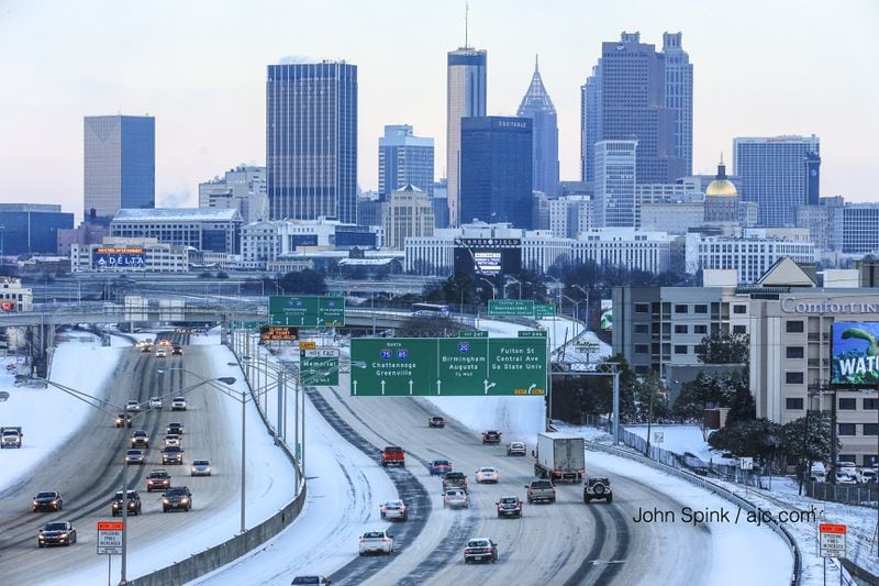 Traffic builds on the Downtown Connector on a snowy Wednesday morning. JOHN SPINK / JSPINK@AJC.COM