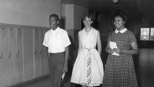The three students selected to integrate Brown High School walk down the hall, possibly on registration day, one day before the school integrated: Thomas Welch, who entered Brown as a junior, would eventually go on to get a master's in city planning from MIT and would become a real estate developer in Boston. Damaris Allen, center, chose to take an early admission to Spelman at age 16 and wound up never attending Brown. Madelyn Nix, right, became a corporate attorney in Pennsylvania. Welch and Nix were on hand in 2011 for an APS ceremony honoring the Atlanta Nine. (Bill Wilson / AJC Archive at the GSU Library AJCP297-004a)