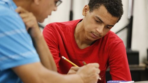 Christian Robinson (right) gets math tutoring from teacher Aleem Shaw to help bring him up to a high school level. BOB ANDRES / BANDRES@AJC.COM
