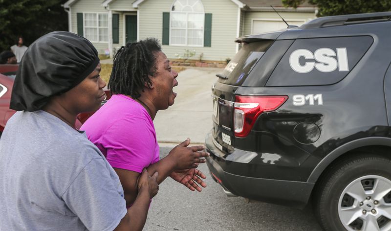 Teletha Walker (center) cried at the scene after learning of her son's death. JOHN SPINK / JSPINK@AJC.COM