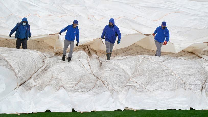 New York Mets groundskeepers pull a tarp over the outfield at Citi Field as a game against the Atlanta Braves was postponed due to rain, Sunday, May 30, 2021, in New York. (Kathy Willens/AP)
