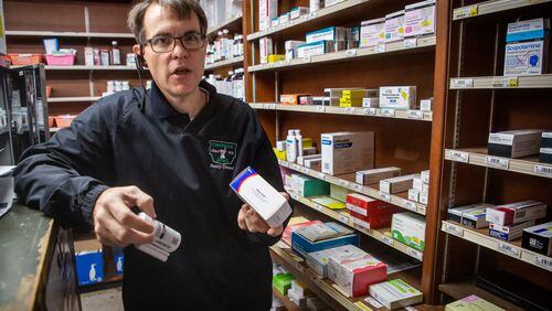 Owner Derek Chapman holds two antivirals at his Hapeville pharmacy, Chapman Drug, last February. (Steve Schaefer for The Atlanta Journal-Constitution)