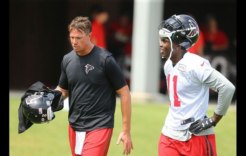073115 FLOWERY BRANCH: Matt Ryan and Julio Jones confer after a play on the the first day of training camp on Friday, July 31, 2015, in Flowery Branch. Curtis Compton / ccompton@ajc.com