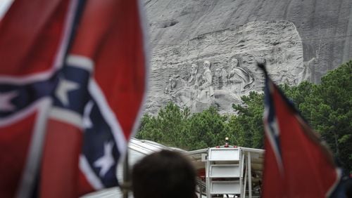Confederate flag sympathizers march past the carved monument at Stone Mountain Park to protest what they believe is an attack on their Southern heritage. (John Amis/ AJC 2015 file photo)