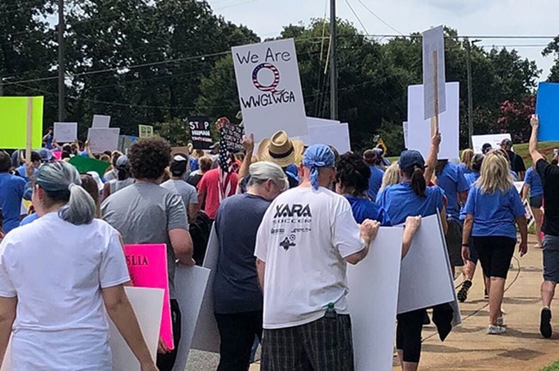 While most marchers carried signs generically in opposition to child sex trafficking, a dozen or so ignored organizers' requests not to carry QAnon posters at the Woodstock event on Saturday, Aug. 22, 2020.  A "We Are Q" sign can be seen in this portion of the march. (Photo: Chris Joyner/AJC)