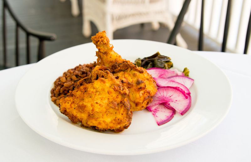 The Farmhouse at Serenbe is known for its flavorful fried chicken, served here with watermelon radishes, beans and collard greens. CONTRIBUTED BY HENRI HOLLIS
