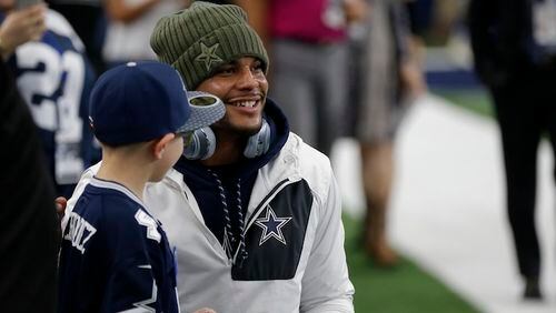 Dallas Cowboys' Dak Prescott poses for a photo with a young fan before an NFL football game against the Kansas City Chiefs on Sunday, Nov. 5, 2017, in Arlington, Texas. (AP Photo/Brandon Wade)