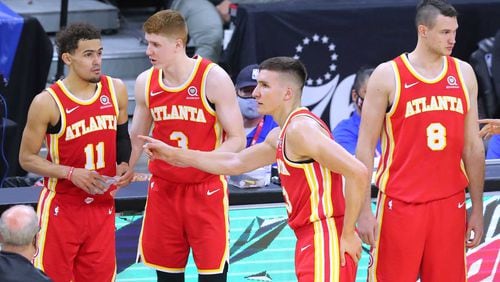 Hawks players Trae Young (from left), Kevin Huerter, Bogan Bogdanovic, and Danilo Gallinari confer during a timeout against the Philadelphia 76ers in game 2 of their NBA Eastern Conference semifinals series on Tuesday, Jun 8, 2021, in Philadelphia.   “Curtis Compton / Curtis.Compton@ajc.com”