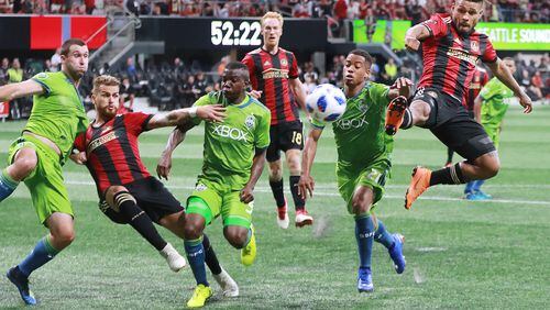 July 15, 2018 Atlanta: Atlanta United midfielder Josef Martinez (right) trys to finish off a corner kick in front of the goal as Seattle Sounders Jordy Delem defends during the second half in a MLS soccer match on Sunday, July 15, 2018, in Atlanta. The teams battled to a 1-1 tie. Nouhou Tolo (left) defends against Leandro Gonzalez Perez on the play.   Curtis Compton/ccompton@ajc.com