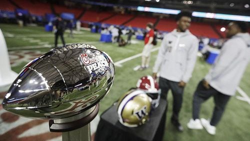 The Chick-fil-A Peach Bowl trophy stands on the field during media day at the Georgia Dome on Thursday. (Photo by David Goldman/AP)