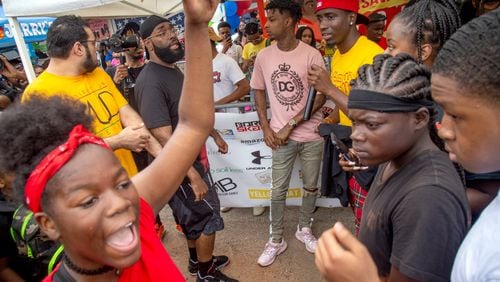 People surround 21 Savage as he walks into the fourth annual Issa Back 2 School Drive on Sunday. STEVE SCHAEFER / SPECIAL TO THE AJC