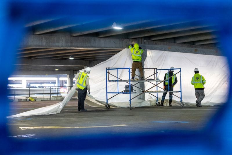 Workers set up a barrier for construction in the North Parking Deck by Hartsfield-Jackson Domestic Terminal in Atlanta on Friday, February 3, 2023. (Arvin Temkar / arvin.temkar@ajc.com)