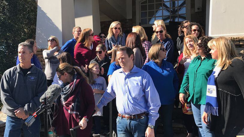 Parents in Forsyth County leave a meeting where they announced they were suing the county over its redistricting of high school students in the south end of the county. “We just object to how this process was done,” said parent Chris Reilly, pictured front and center in the blue shirt. Marlon A. Walker.