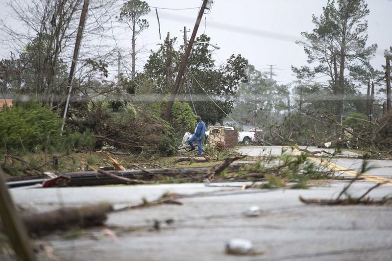A man steps over debris in a neighborhood that was damaged by a Tornado, Monday, Jan. 23, 2017, in Albany, Ga. (AP Photo/Branden Camp)