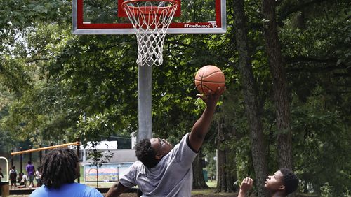 Camp Best Friend students and counselors play a game of basketball following a ribbon cutting ceremony for the  new basketball court at Pittman Park on Wednesday, July 13, 2022. The court  will be a part of Mayor Dickens’  Midnight Basketball initiative created to give youth a place to spend time. (Natrice Miller/natrice.miller@ajc.com)