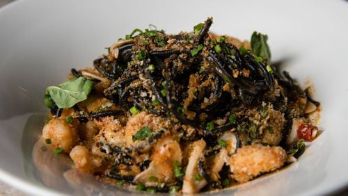 Squid Ink Tonnarelli at Bar Americano dresses a bed of long, black noodles with rock shrimp, calamari, garlic, basil and breadcrumbs. CONTRIBUTED BY HENRI HOLLIS