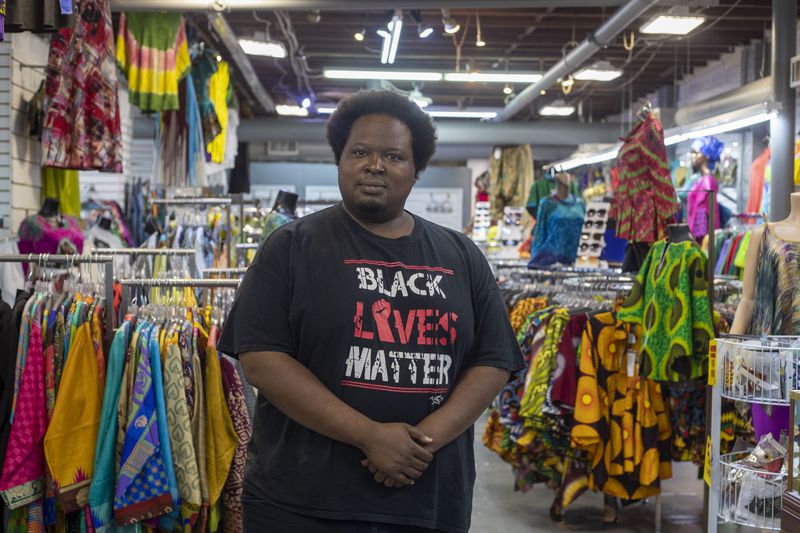 Afro-Centric Network manager Mugaisi Andega stands for a portrait inside his family's store in Atlanta’s West End community, Wednesday, August 25, 2021. (Alyssa Pointer/Atlanta Journal Constitution)