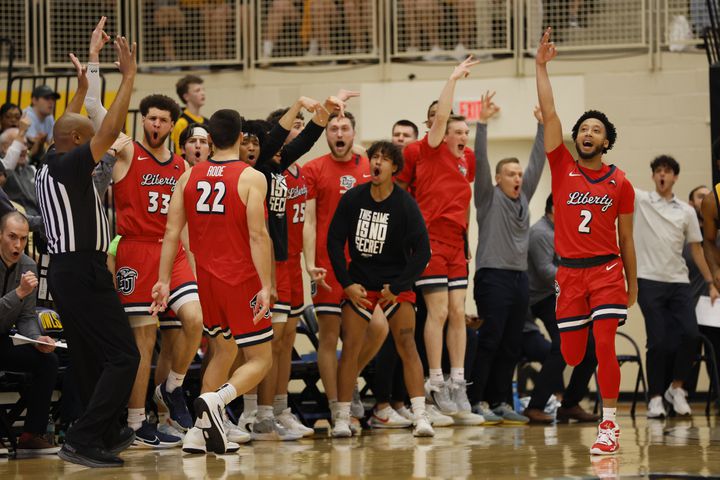 Liberty Flames players react with forward Kyle Rode (22) after scoring a three-pointer against the Kennesaw State Owls at the Kennesaw State Convention Center on Thursday, Feb 16, 2023. Miguel Martinez / miguel.martinezjimenez@ajc.com