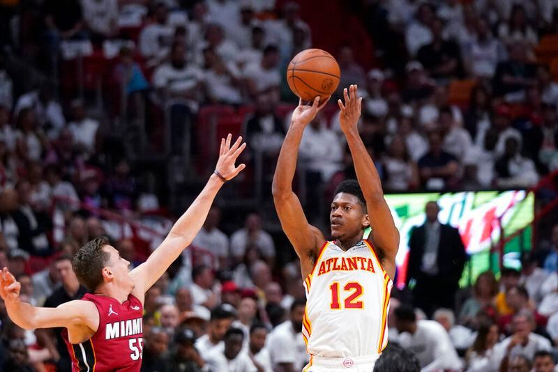 Atlanta Hawks forward De'Andre Hunter (12) takes a shot against Miami Heat forward Duncan Robinson (55) during the first half of Game 5 of an NBA basketball first-round playoff series, Tuesday, April 26, 2022, in Miami. (AP Photo/Wilfredo Lee)