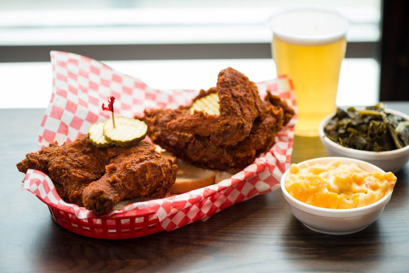 Hattie B's Hot Chicken 1/2 Bird Plate served with two sides, bread, and pickles. Pictured are Pimento Mac and Cheese and Southern Greens sides with a draft beer. Photo credit- Mia Yakel.