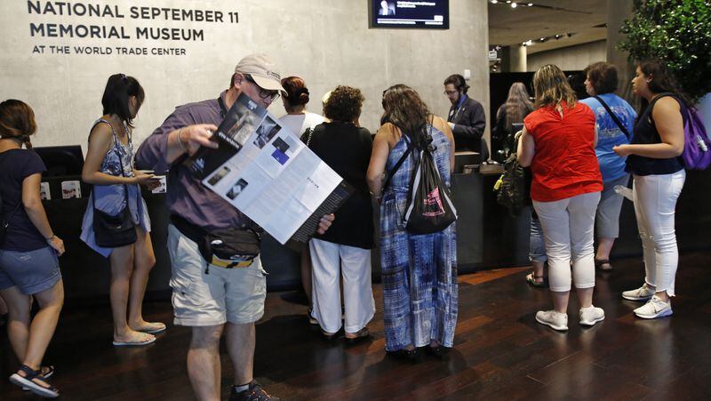 In this July 11, 2017 photo, visitors to the National September 11 Memorial and Museum pick up maps and guides in New York. Last winter the U.S. tourism industry worried about a "Trump slump," fearing that Trump administration policies might discourage international travelers from visiting the U.S. But statistics from the first half of 2017 suggest that the travel to the U.S. is robust and a number of sectors have reported increased international visitation, with one expert calling it a "Trump bump." The museum is among those reporting more international visitors this year compared to the same period in 2016. (AP Photo/Kathy Willens)